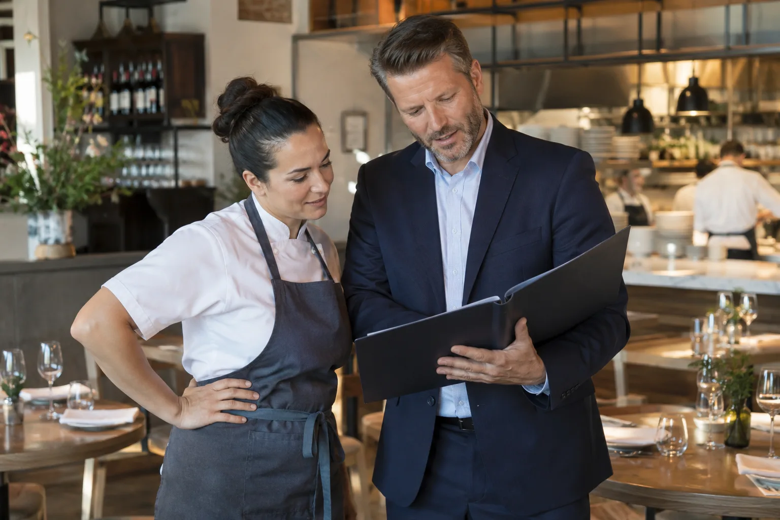 restaurant owner and insurance professional reviewing a simple document folder